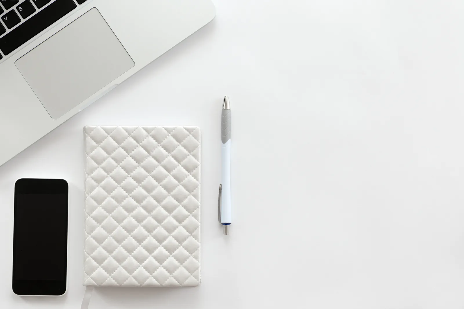 Minimalist white desk with laptop and smartphone — Le Web Studio, multilingual website creation for Mexican tourism